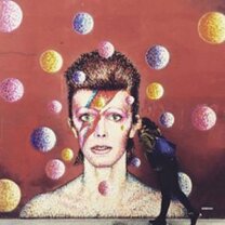 Graffiti of woman against red wall and yellow, blue, pink circles in London